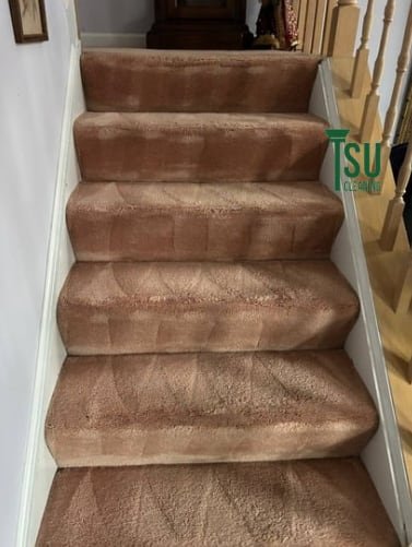 The same staircase after cleaning, with the original carpet color restored on each tread